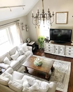 a living room filled with furniture and a flat screen tv on top of a wooden table