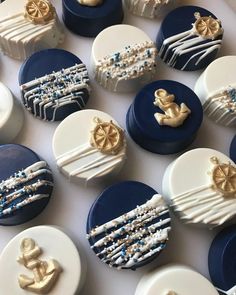 many decorated cookies are sitting on a table together, with blue and white icing