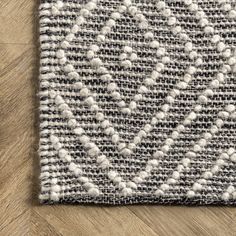 an area rug on the floor with white and gray colors, including black and grey dots