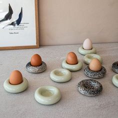 an assortment of eggs sitting on top of donuts in front of a framed photo