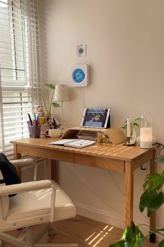 a wooden desk with a laptop computer on top of it next to a chair and window