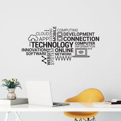 a laptop computer sitting on top of a desk next to a wall mounted with words