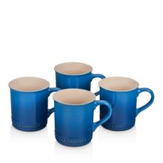 four blue and beige coffee mugs sitting next to each other