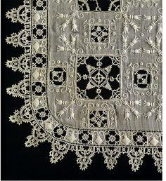 a piece of cloth with white lace on it and an intricate design in the center