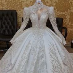 a white wedding dress with long sleeves on display