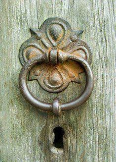 an old door handle is shown with a hole in the middle and a flower design on it