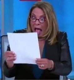 a woman holding a piece of paper in front of her face and making a funny face