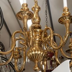 a gold chandelier hanging from the ceiling in a room with many other items