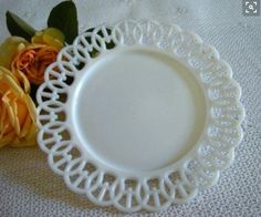 a white plate sitting on top of a table next to flowers