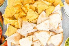 tortilla chips, guacamole and salsa are on the table ready to be eaten