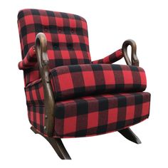 a red and black checkered chair sitting on top of a wooden base with an arm rest