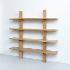 a wooden shelf sitting on the side of a wall next to a white wall and floor