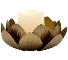 a candle is sitting on top of a wooden bowl with leaves and petals around it