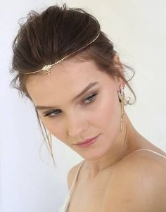 a young woman wearing a head piece with gold chains on it's head and hair comb in her hair