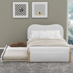 a white bed sitting in a bedroom on top of a carpeted floor next to a window