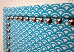 a close up of a wall hanging with beads on the bead and in front of it