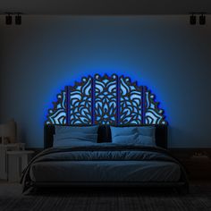 a large bed sitting under a blue light in a bedroom