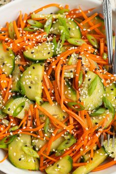 a salad with carrots, cucumbers and sesame seeds