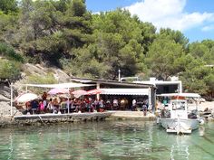 a group of people sitting at tables near the water