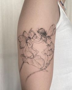 a woman with a tattoo on her arm that has two little fairy tinkerbells