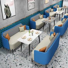 an empty restaurant with blue and white chairs, tables and pictures hanging on the wall