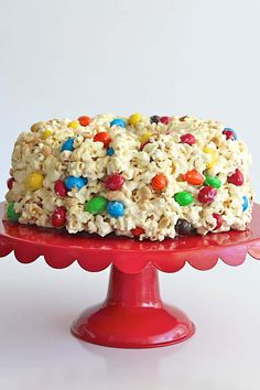 a cake that is on top of a red plate with the words, peanut popcorn cake