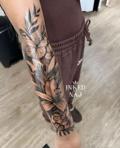 a woman's arm with flowers and leaves on it