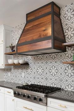 a stove top oven sitting inside of a kitchen next to a wallpapered backsplash