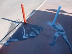 the shadow of a baseball player is painted on the ground next to an orange pole