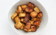 a white bowl filled with cooked cubed potatoes