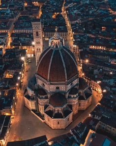 an aerial view of a large building in the middle of a city at night time