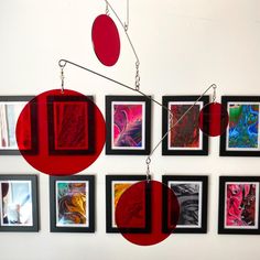 a group of framed pictures hanging on the wall next to each other with red circles