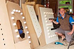 a man is sitting in front of large letters