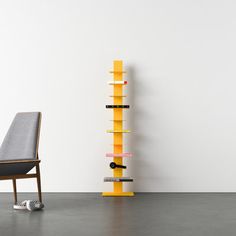 a chair sitting next to a tall yellow shelf