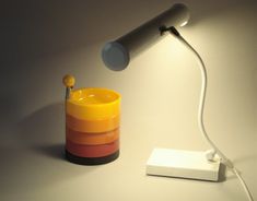 a lamp that is sitting on top of a table next to a cup with a spoon in it