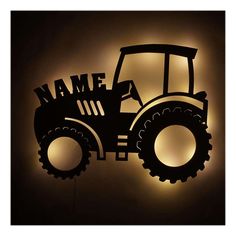 a tractor silhouetted against a wall with the word name on it's front