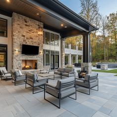 an outdoor living area with couches, chairs and a television mounted to the wall