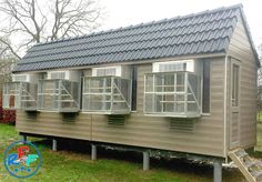 a small wooden house with windows on the roof