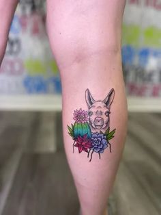 a woman's leg with a tattoo of a pig and flowers on it,