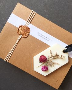 a gift wrapped in brown paper with flowers on it