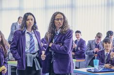 two girls in school uniforms standing next to each other with their arms crossed and looking at the camera