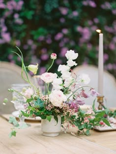 the table is set with flowers and candles