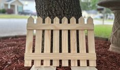 a wooden bench sitting next to a tree