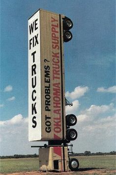 a large sign sitting in the middle of a field