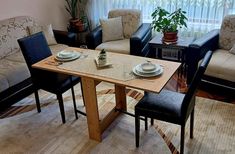 a living room with couches, chairs and a table in front of a window