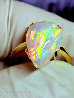 14k solid gold ring, with a very colorful natural crystal opal, the light purple background sets the colors aflame. The stone is 11x15mm and 4.74cts. This stone was very hard to photograph, as you can see I used different backgrounds,  the pics with the white gloves seem to be the best, but still not a true depiction of this beautiful stone, not even close. Will tighten the prongs when the ring size is determined. Unique Yellow Gold Ethiopian Opal Ring, Iridescent Opal Ring As A Gift, Iridescent Opal Ring Perfect For Gifts, Iridescent Opal Ring Gift, Multicolor Opal Ring Gift, Multicolor Opal Round Ring, Multicolor Opal Gemstone Ring, Multicolor Opal Ring, Olive Necklace