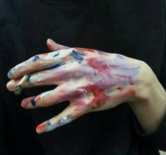 a person with their hands painted red, white and blue while holding something in his left hand