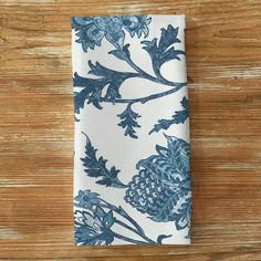 a blue and white flowered napkin sitting on top of a wooden table