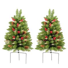 two christmas trees with pine cones and red berries on them are shown in front of a white background