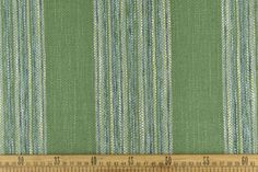 a ruler is next to a green and blue striped fabric